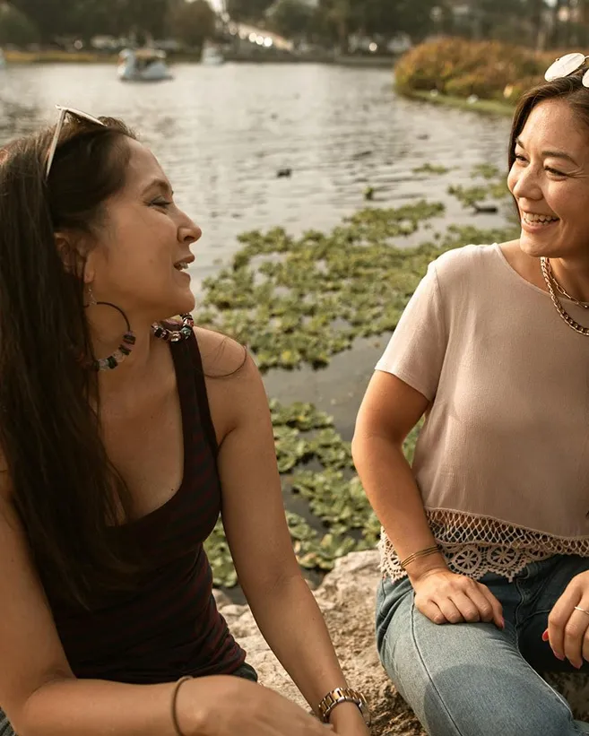 two women laughing by water